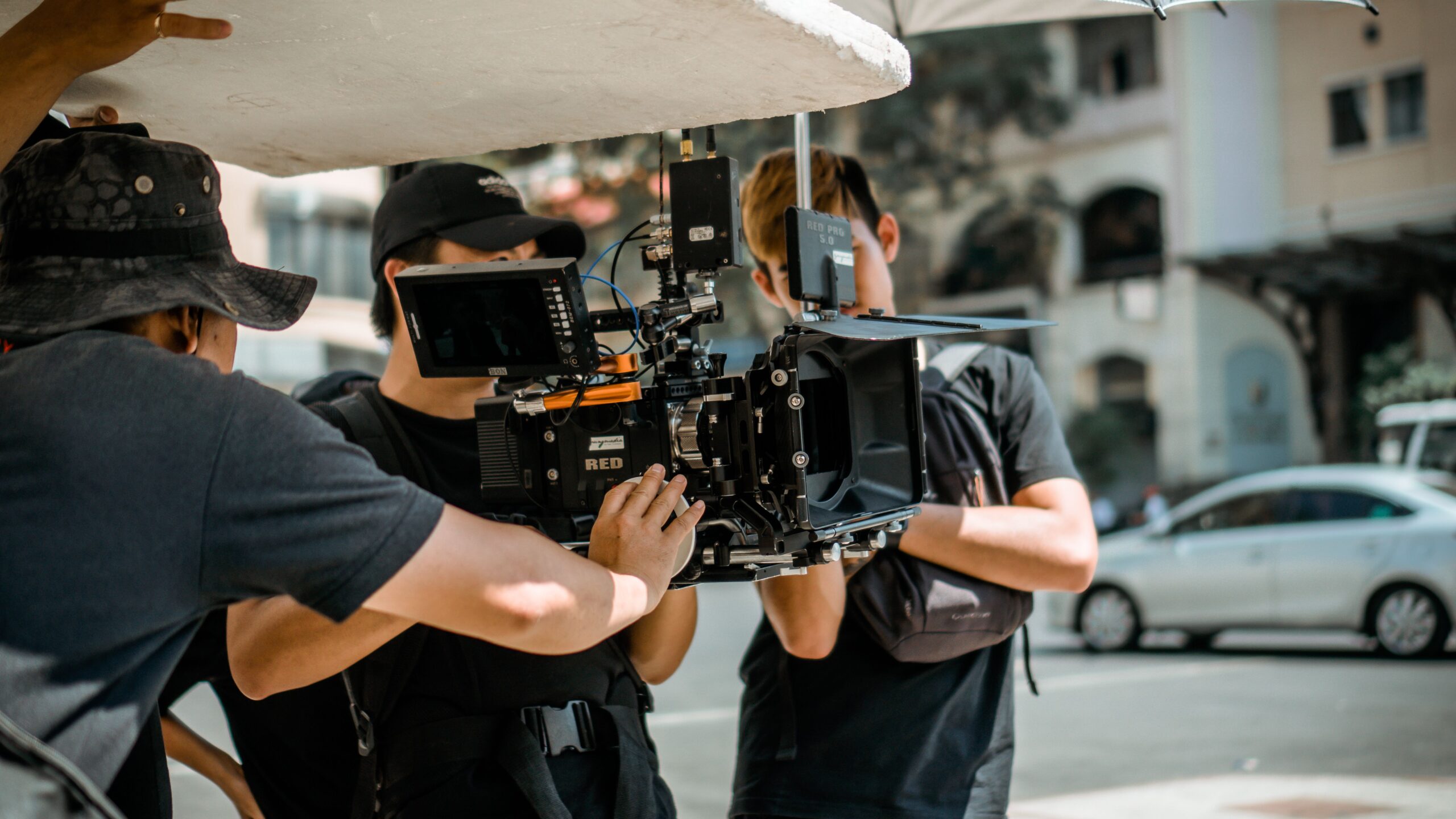 A high-end professional digital cinema camera mounted on a stabilization rig during an active indoor studio film shoot.