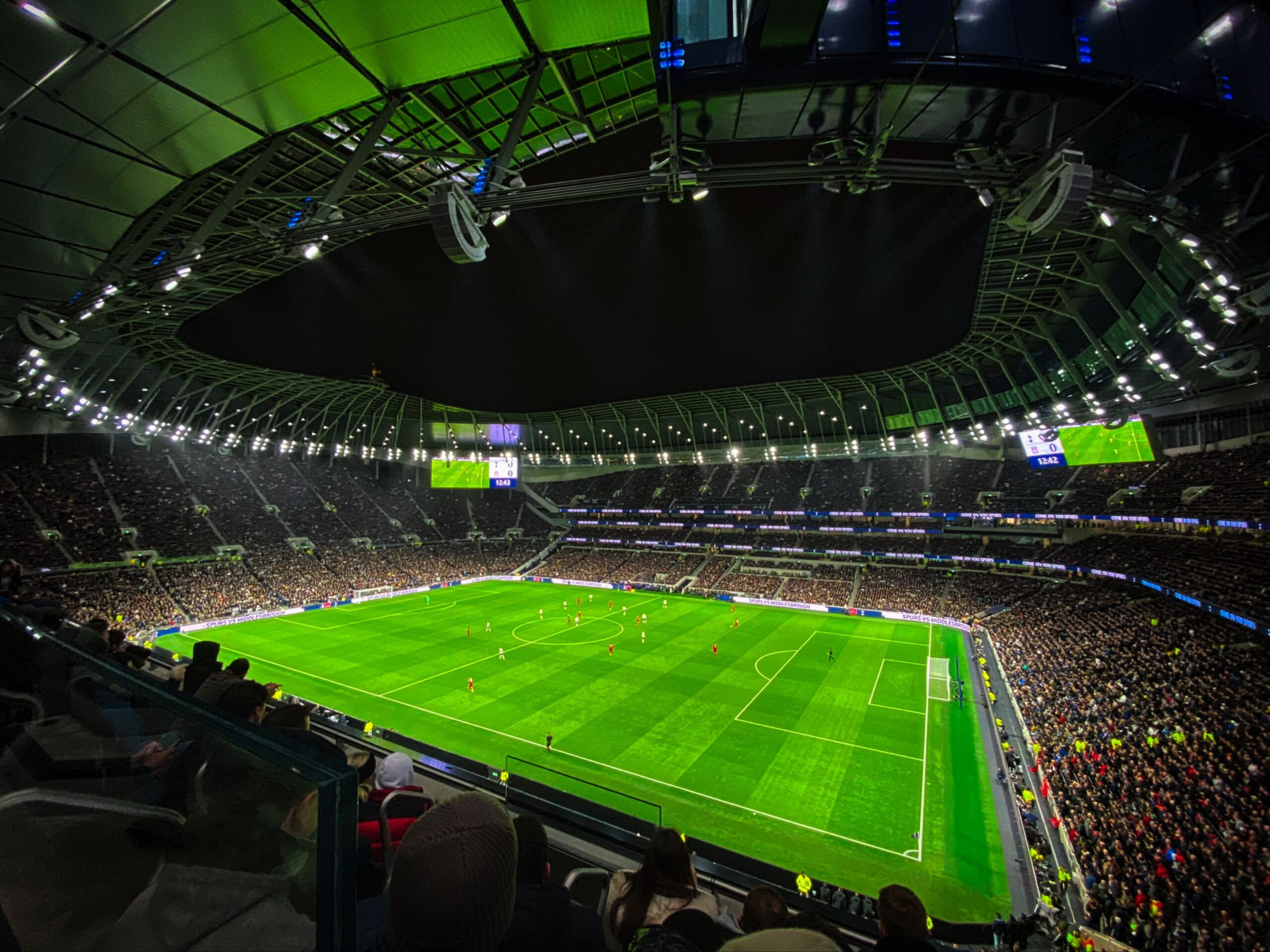 A professional modern empty football stadium green field visual layout under deep cinematic twilight cloud formations
