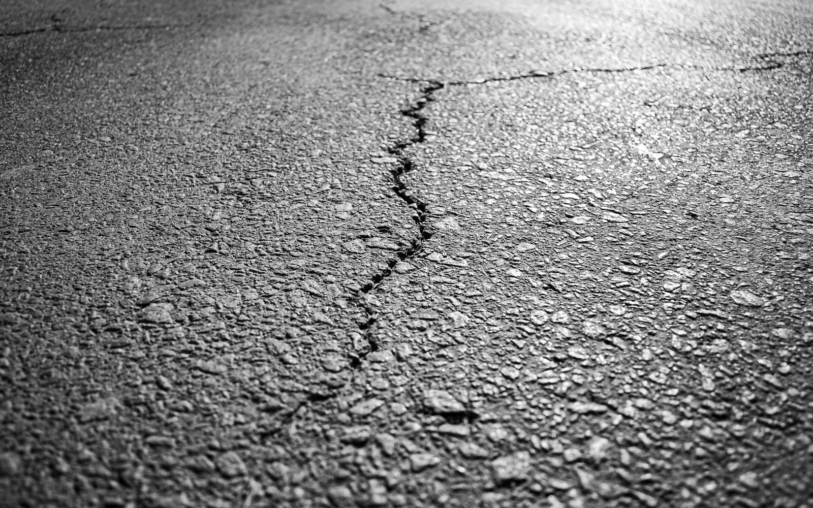 A professional editorial journalism photograph showcasing severely buckled asphalt and cracked municipal road infrastructure representing climate change warping infrastructure Canadian cities metrics