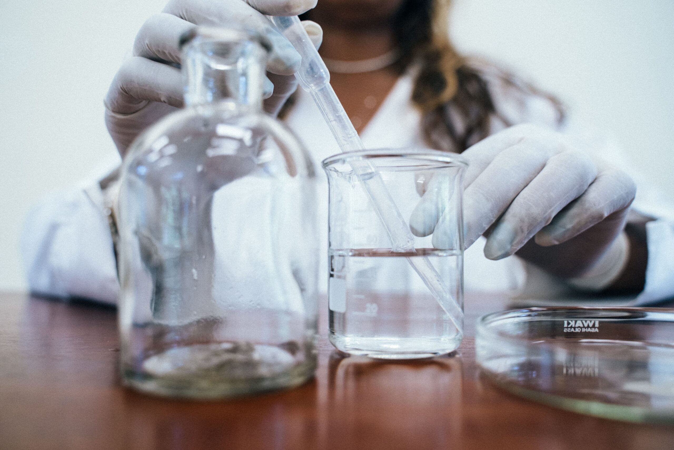 A professional product journalism photograph showcasing clear luxury water bottles and scientific laboratory testing tools representing Costco best bottled water sommelier metrics