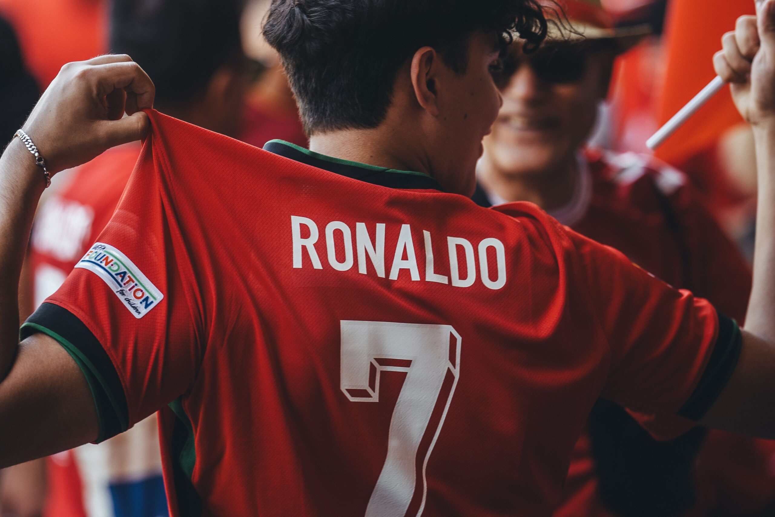 A high-quality sports journalism photograph capturing a legendary football icon walking off the pitch in emotional distress under intense stadium lights