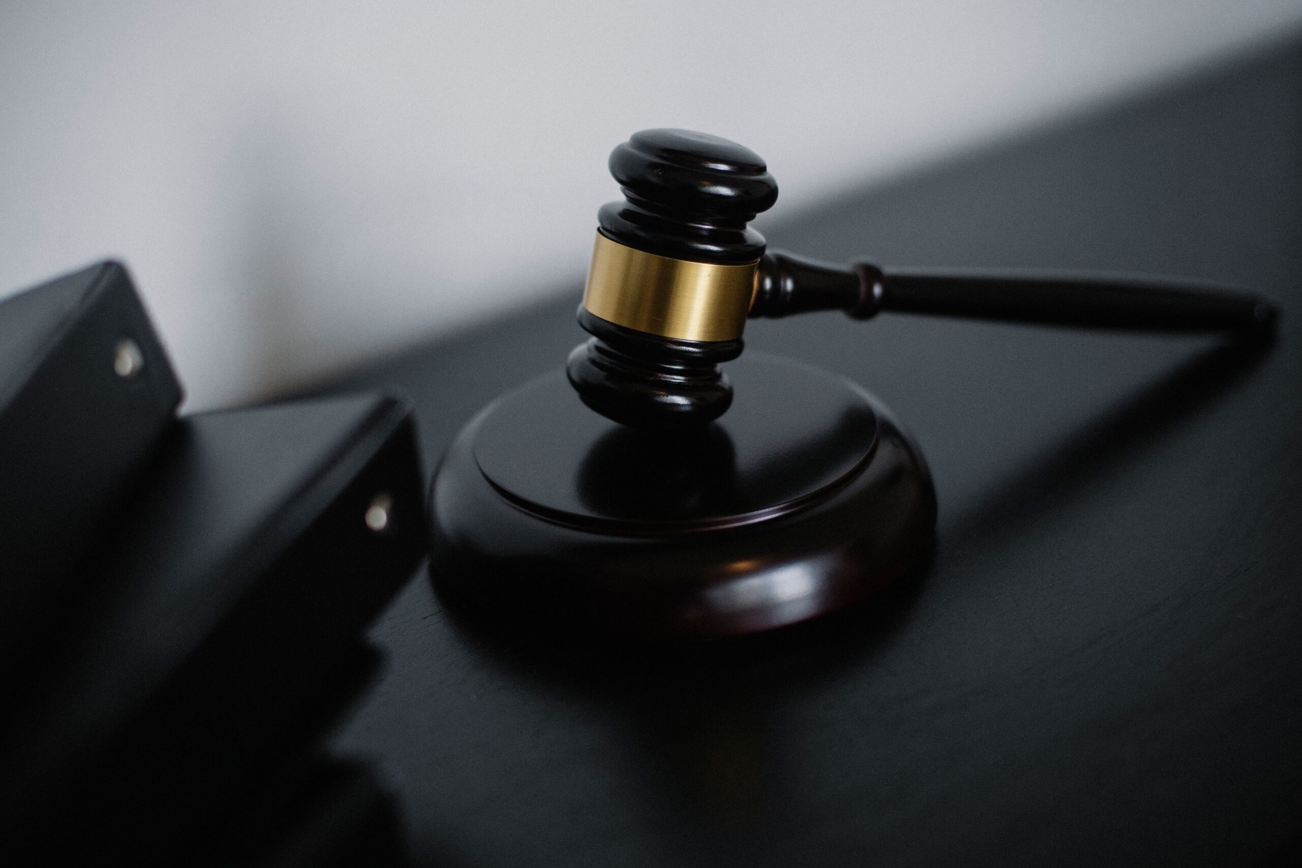 A professional sports journalism photograph displaying an official legal gavel placed neatly on corporate documentation over a dark mahogany boardroom table