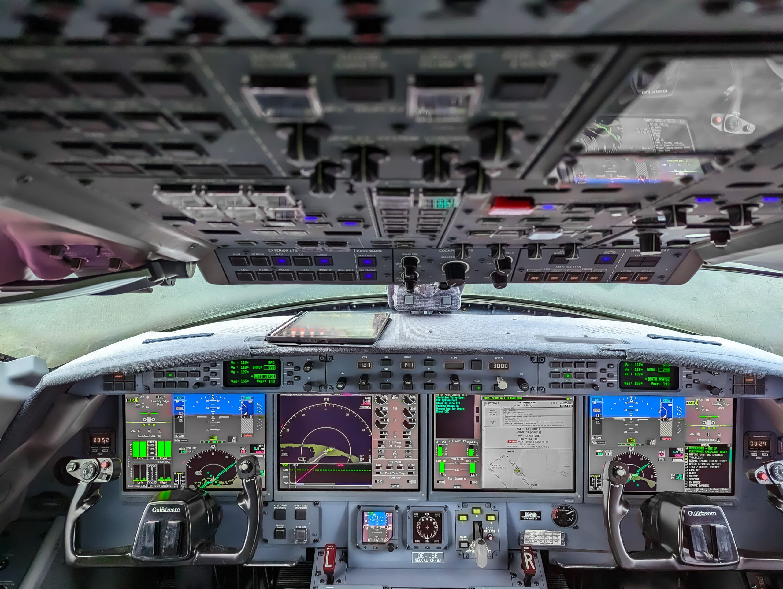 A close-up view of a commercial airplane cockpit panel with illuminated digital flight gauges
