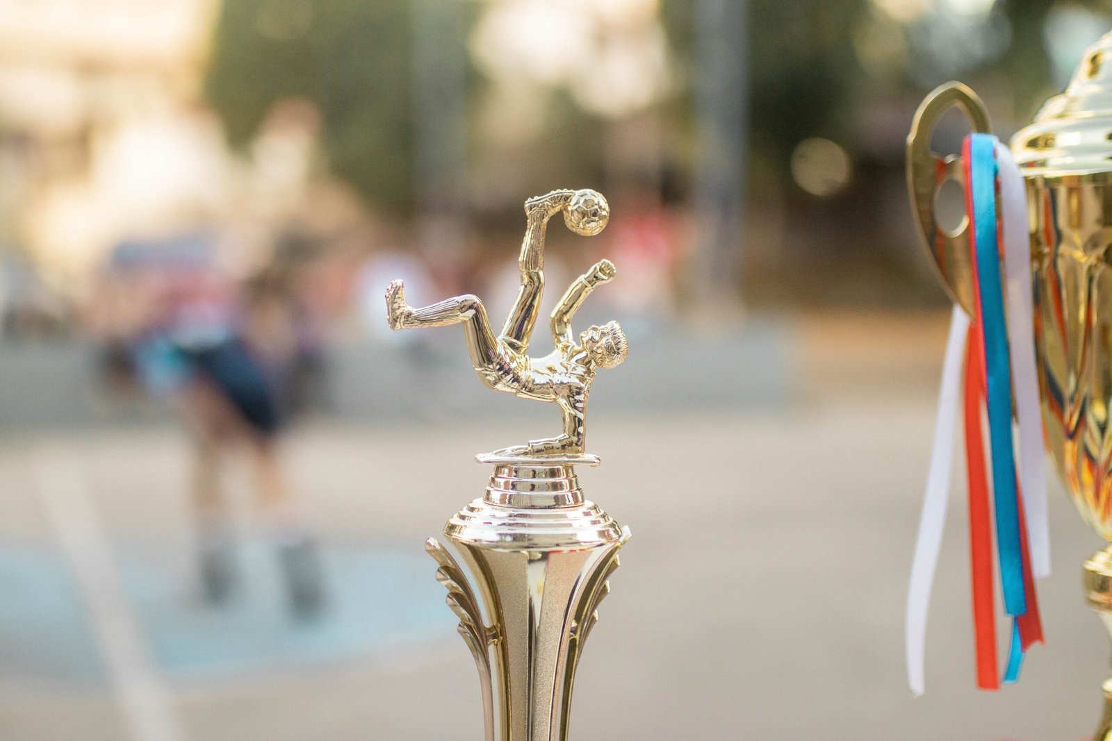 A crisp detailed close-up shot capturing a shiny golden soccer trophy representing the official awards matrix presented at the stadium.