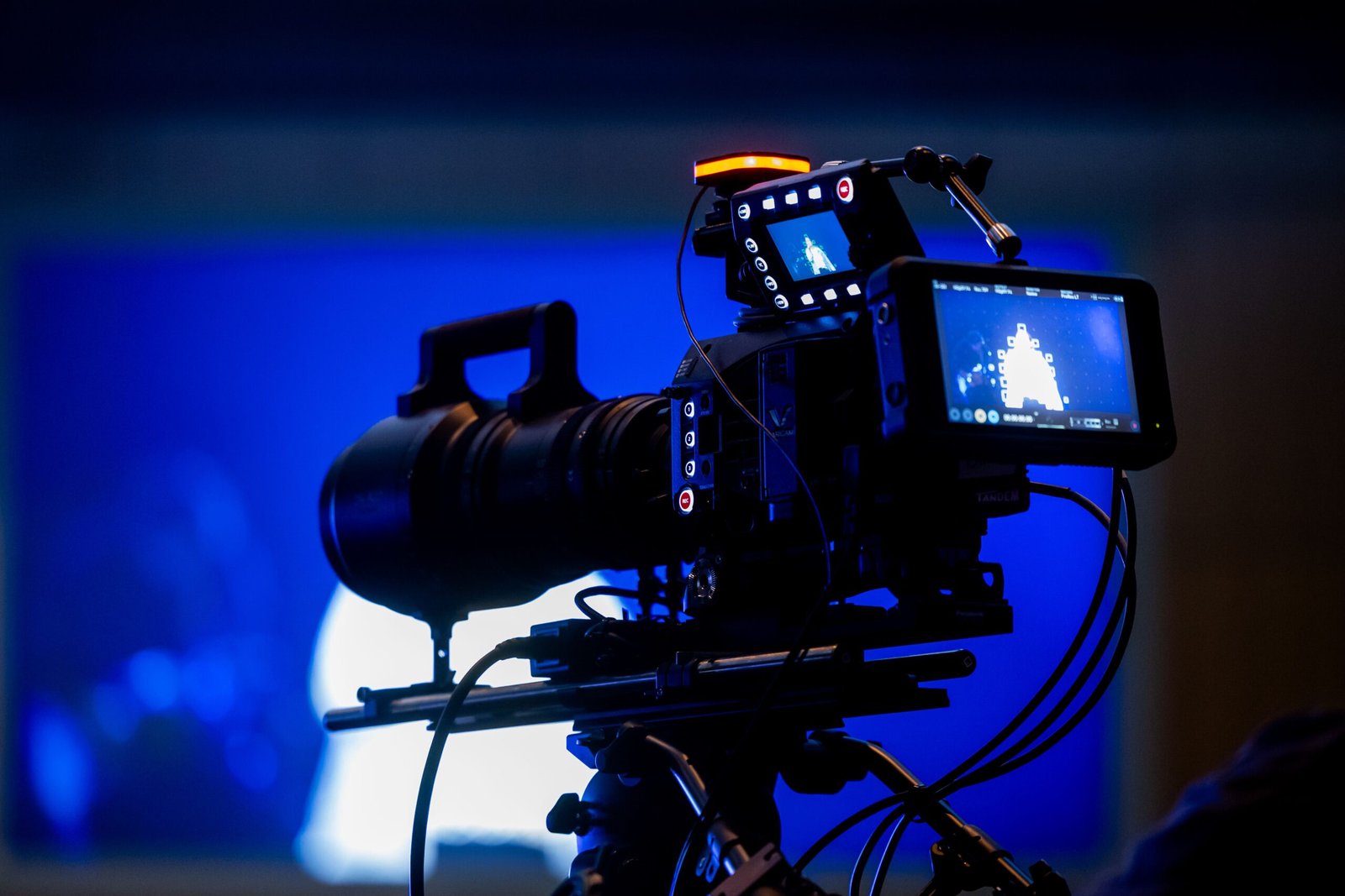 A cinematic video camera focused on a digital monitor showing neural network graphics.