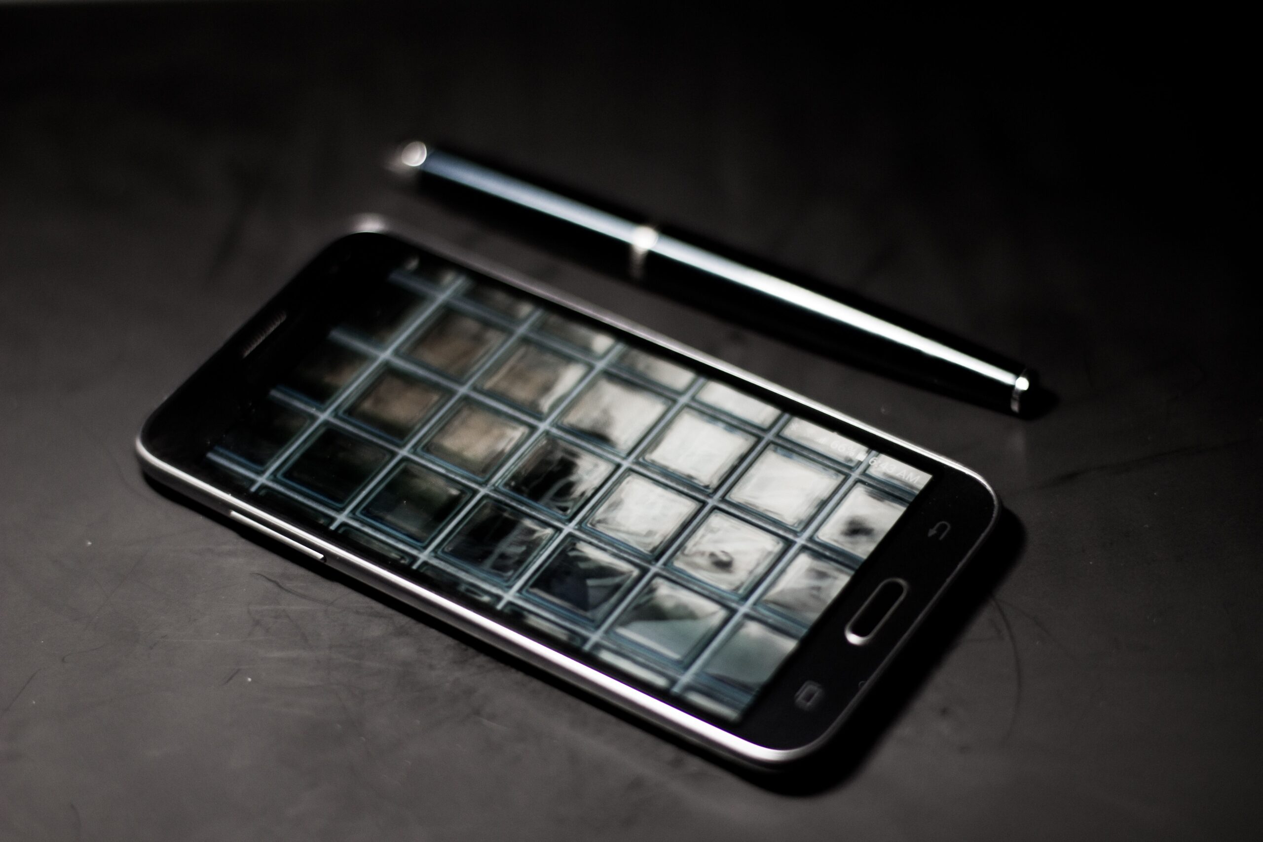 A professional technology journalism photograph showcasing a sleek, ultra-premium smartphone crafted with matte titanium textures resting on a dark executive marble desk