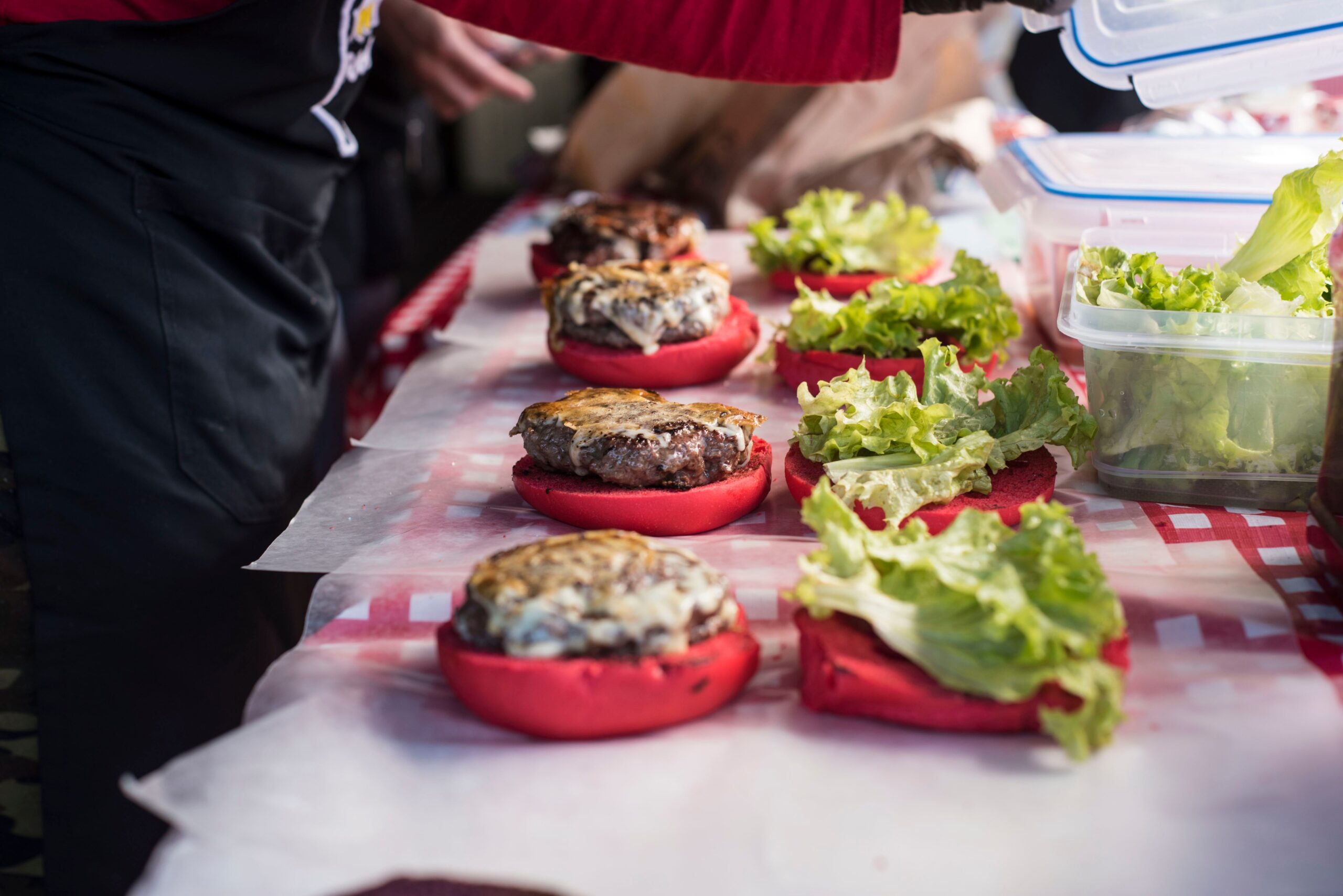 A professional lifestyle journalism photograph capturing a vibrant, high-end street food presentation layout inside a lively outdoor festival setting