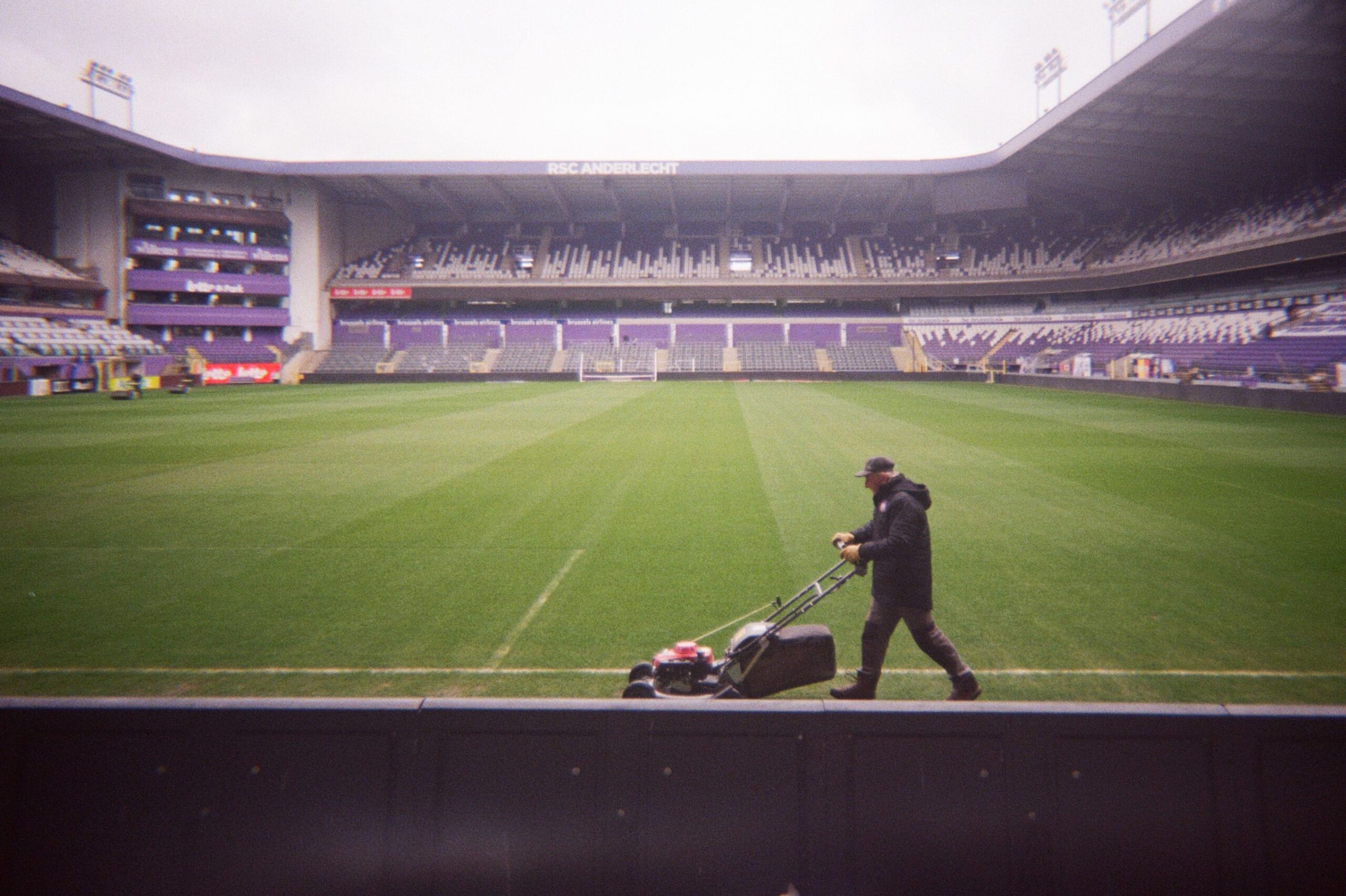 A professional sports media photograph showcasing an empty football stadium during twilight hours representing a tribute to Jayden Adams South Africa midfielder