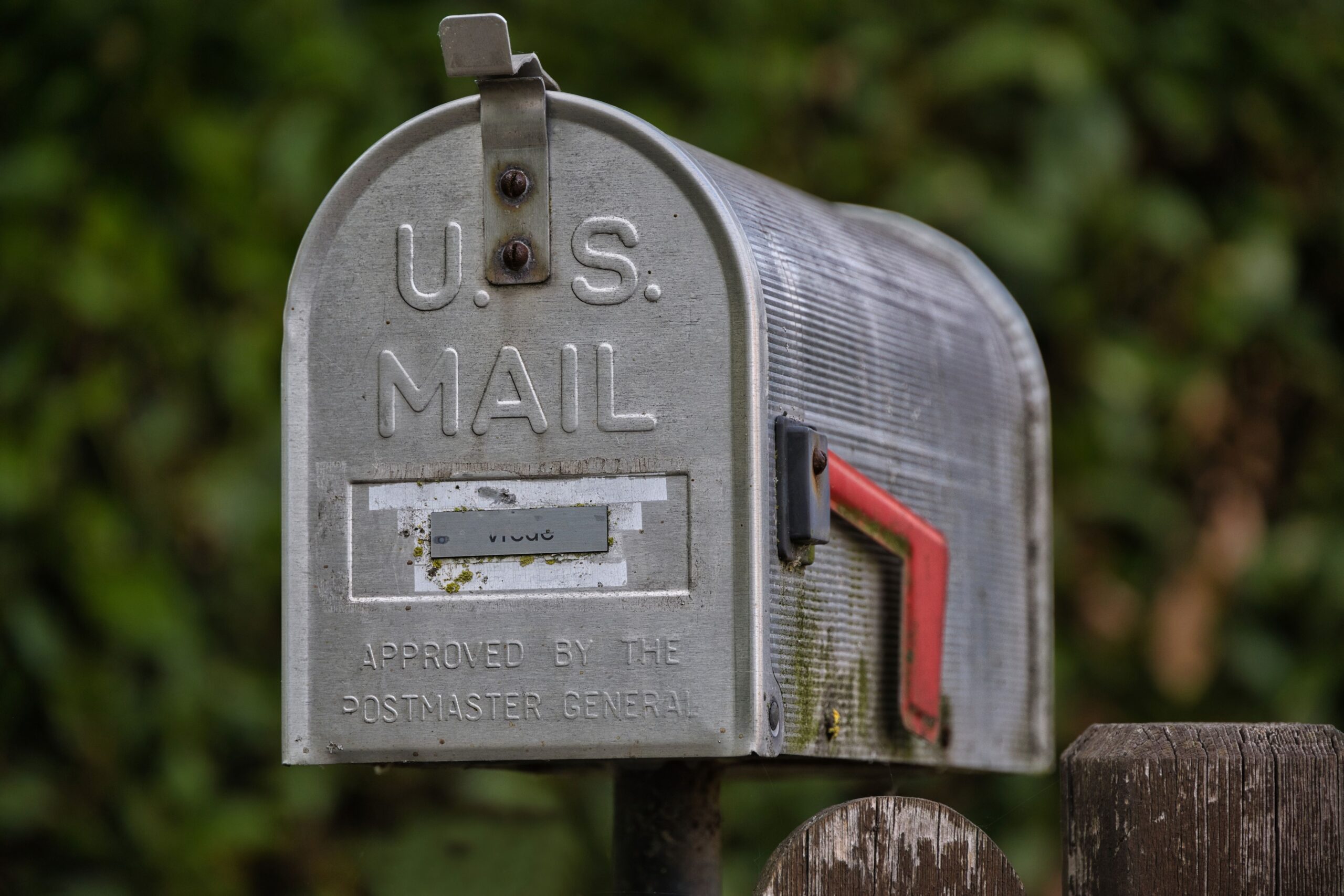 An official blue post office mail drop box standing on a clean concrete street sidewalk