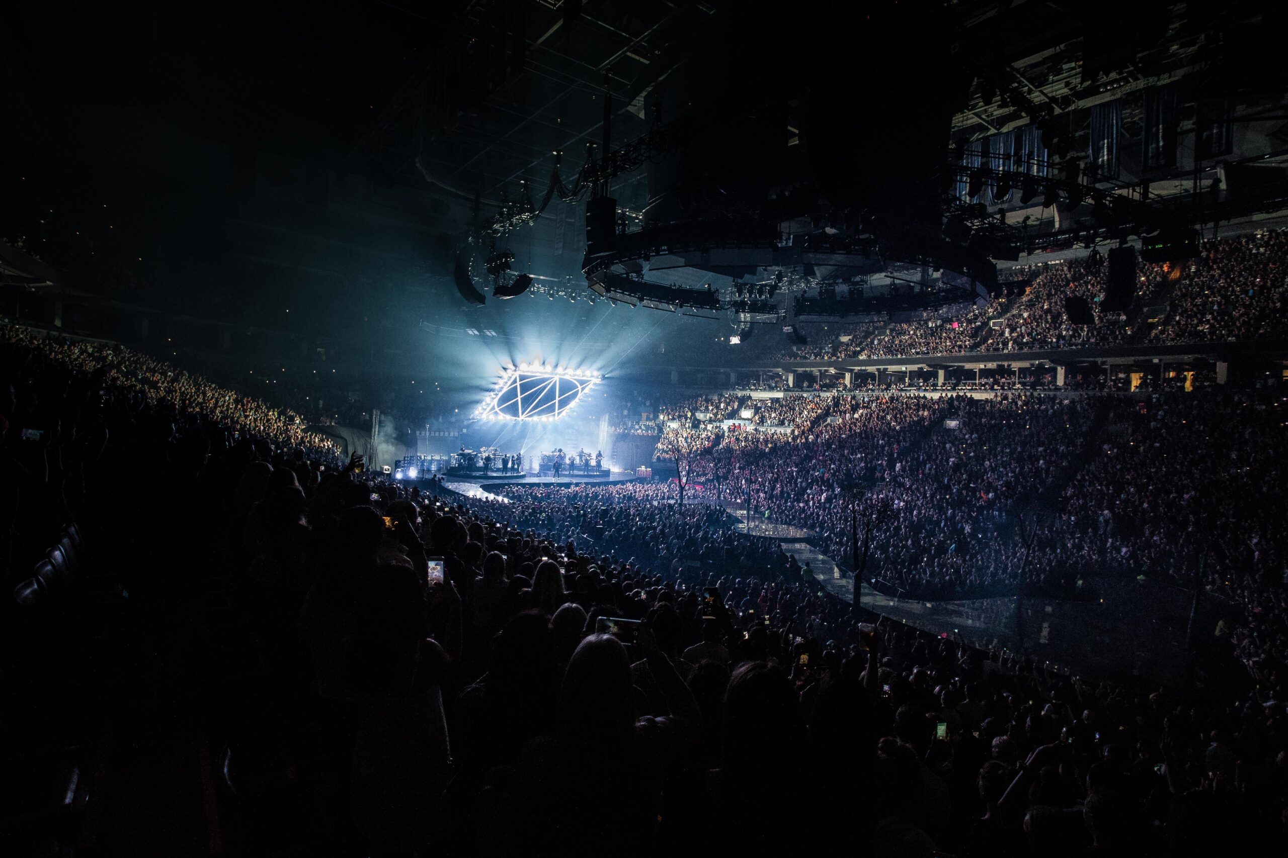 A high-quality sports entertainment journalism photograph capturing a massive, illuminated modern stadium arena during a mega cultural musical event