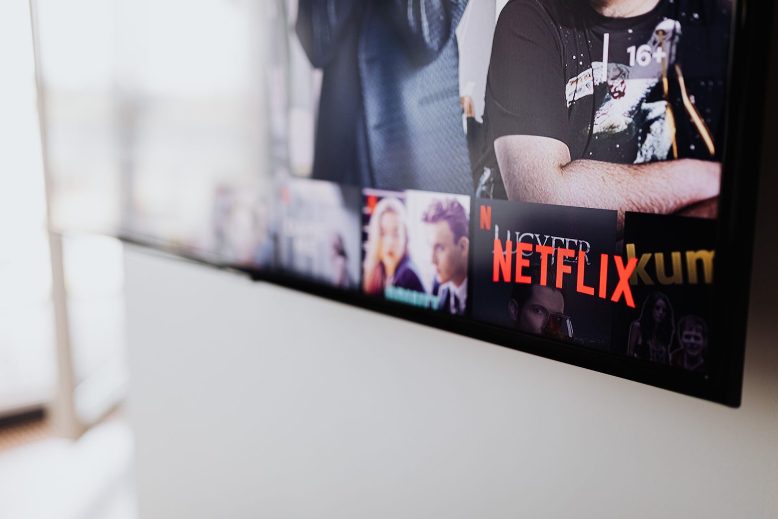 A professional financial media photograph capturing abstract neon terminal illumination reflecting on glass surfaces representing the context of the Netflix stock market correction analytics