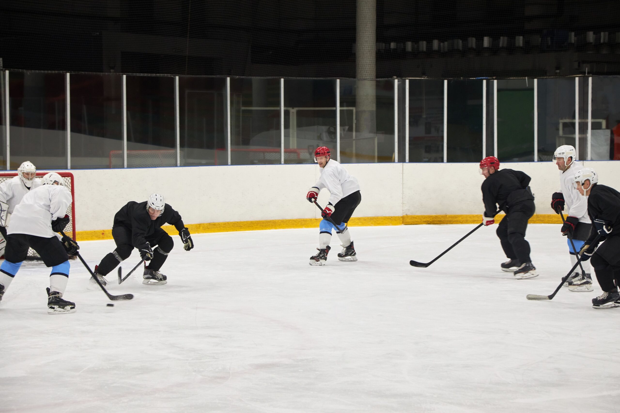 An empty ice hockey rink stadium interior with clear white ice surface under bright arena lights
