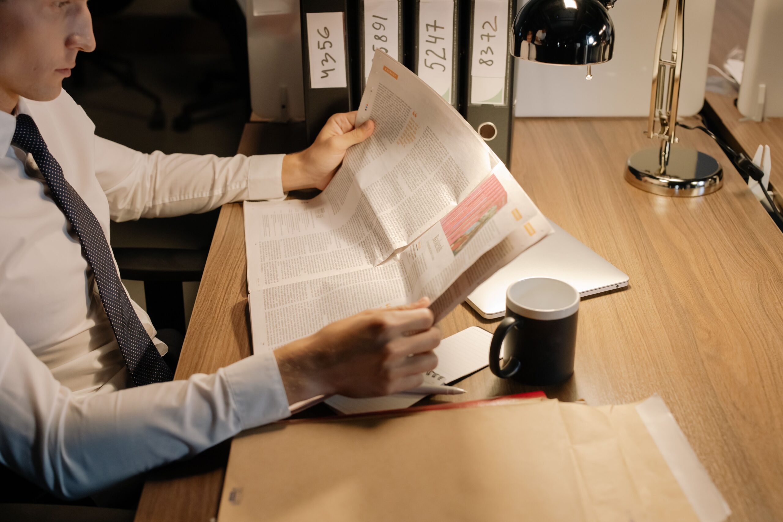 A professional financial journalism photograph showcasing official corporate billing records and federal audit documents arranged on a dark wooden executive table