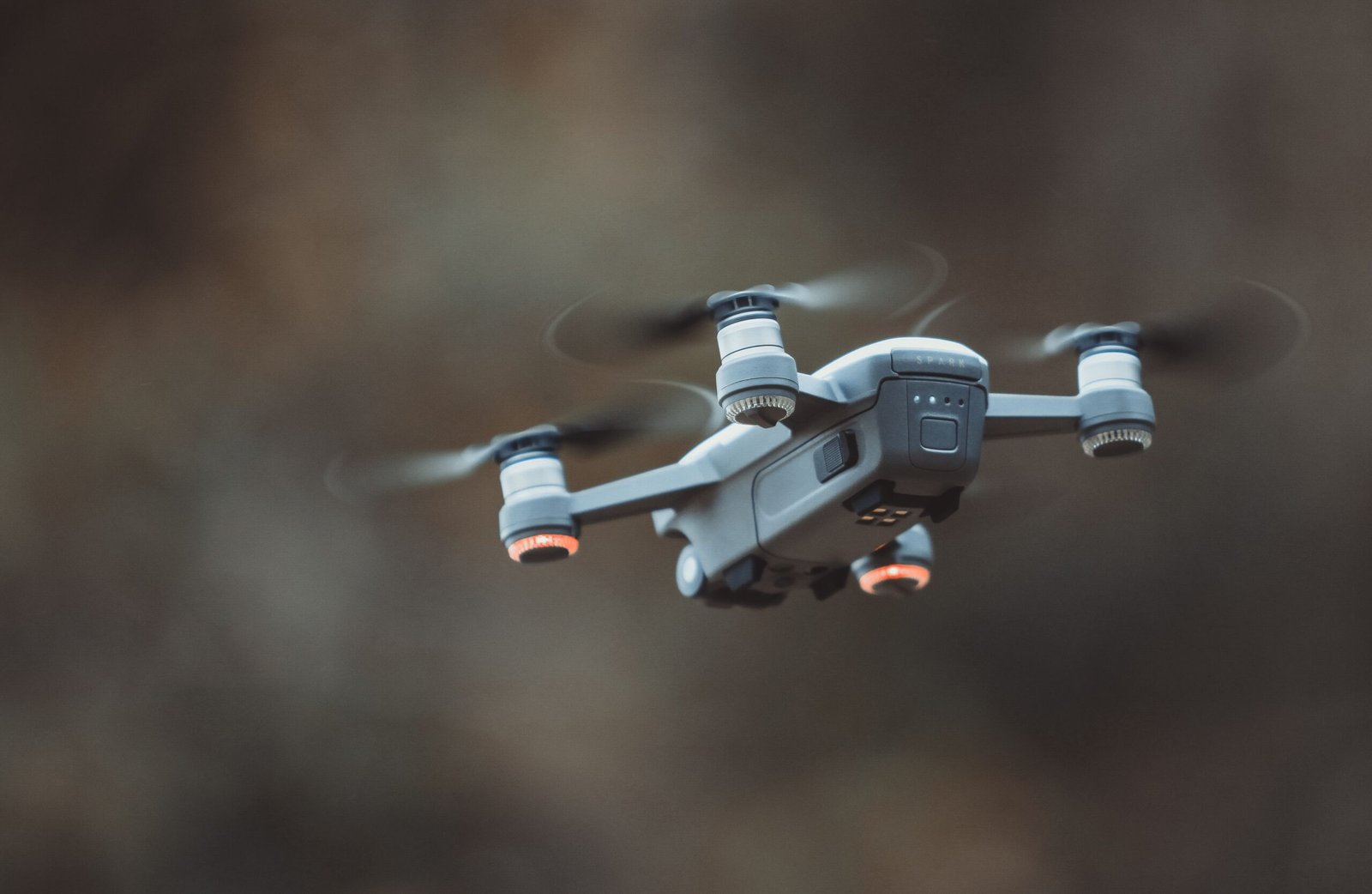 A high-tech single rotor drone hovering in mid-air with dynamic rotational blur effects.