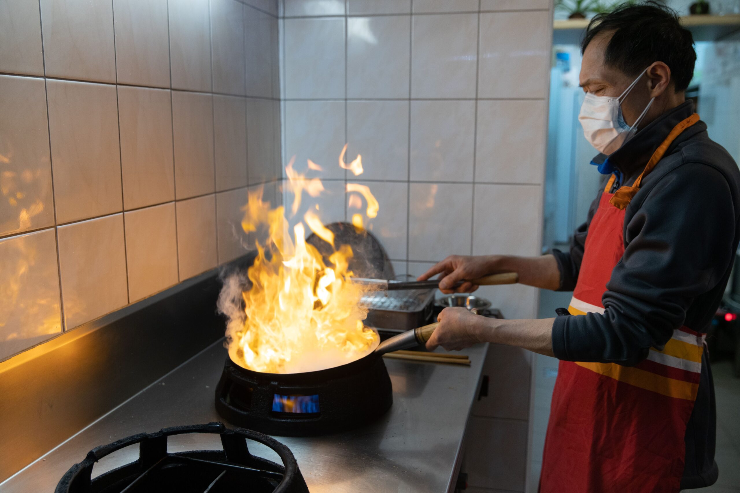 A professional culinary journalism photograph showcasing fresh premium ingredients being tossed inside a hot traditional wok with vibrant flame elements