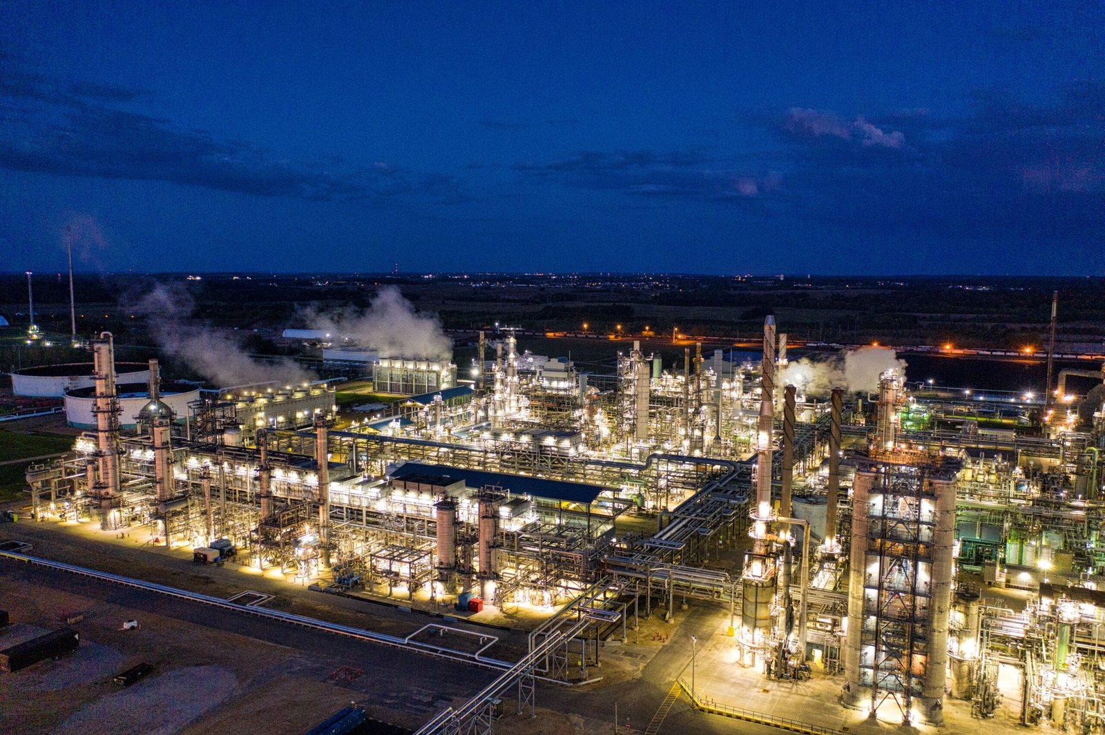 A professional energy journalism photograph capturing heavy industrial processing tower setups representing how the context of the Reliance Industries Q1 fiscal earnings statement builds
