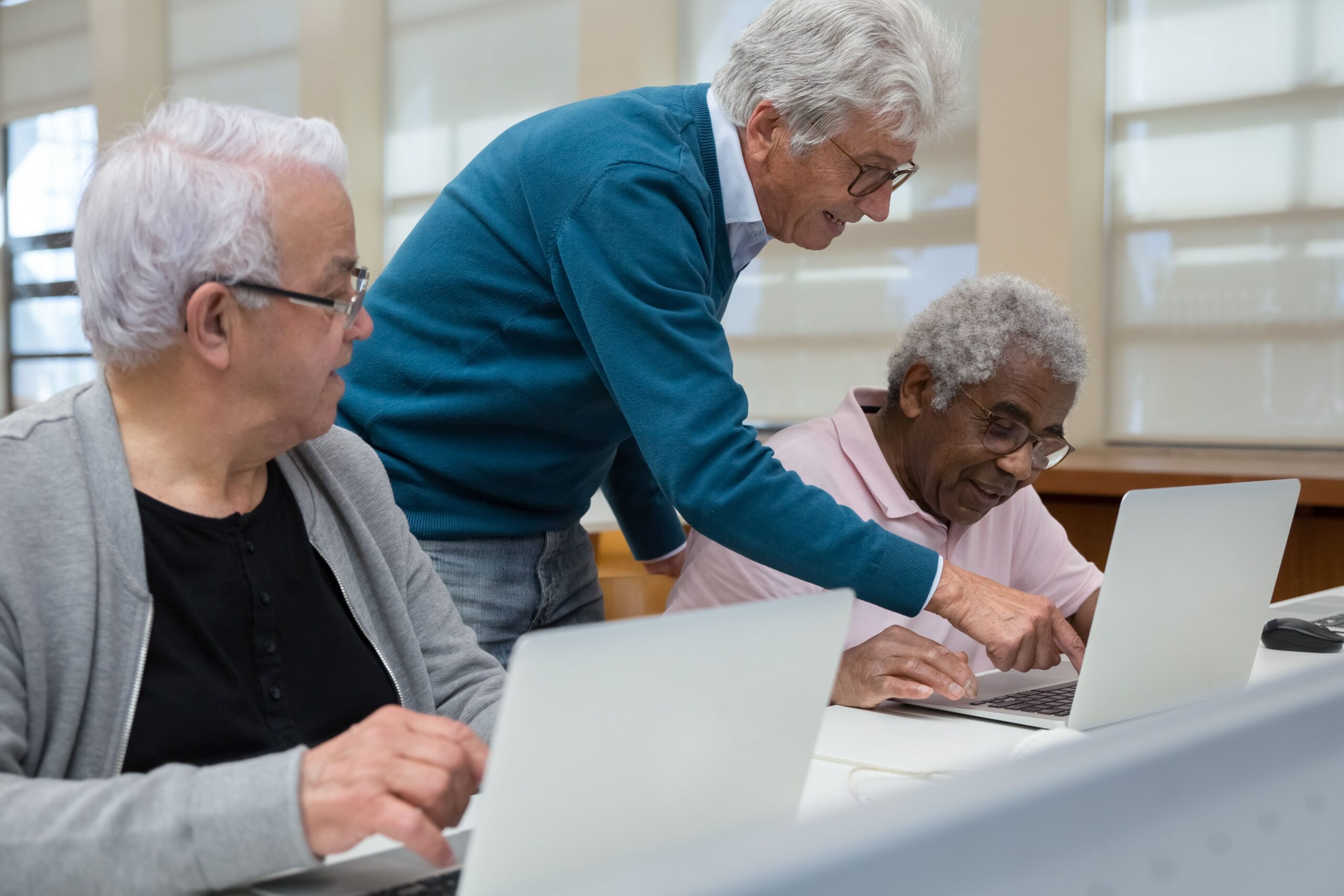 An elderly couple reviewing tax calculations and financial documents together at a wooden table