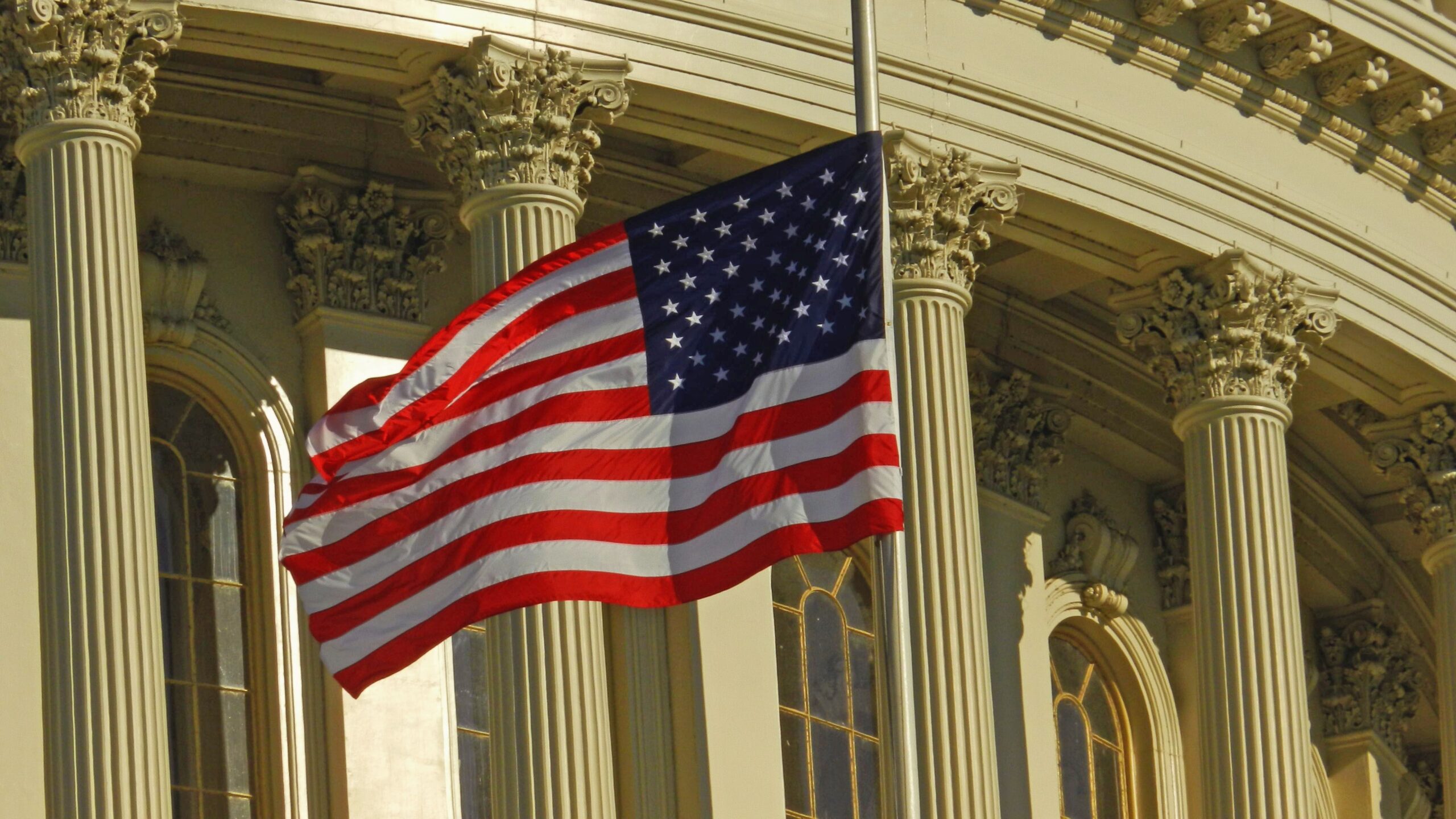 A professional political journalism photograph showcasing the United States Capitol dome under clear blue skies representing a tribute after Senator Lindsey Graham dies