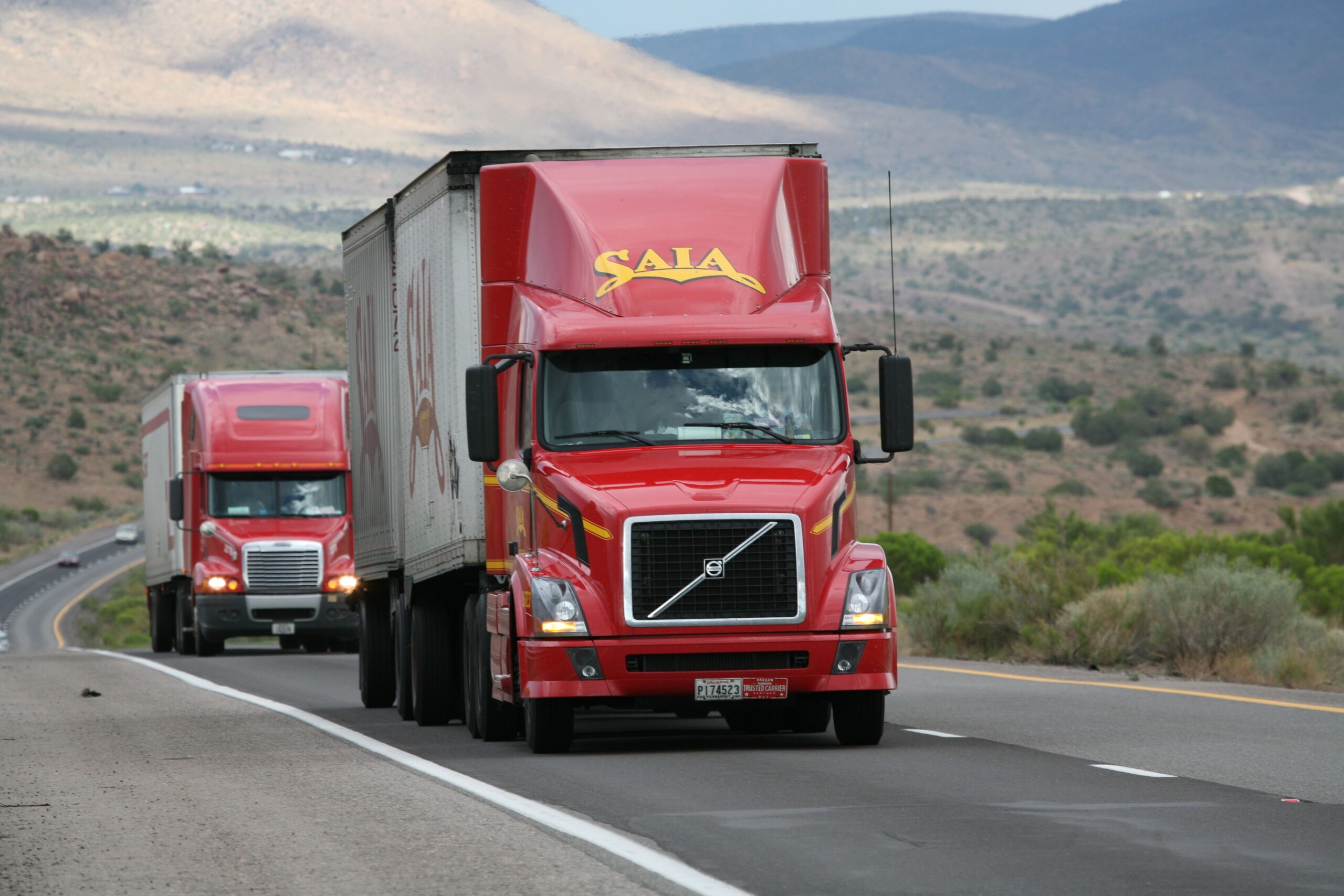 A modern clean highway landscape showing an electric commercial cargo truck driving at dusk