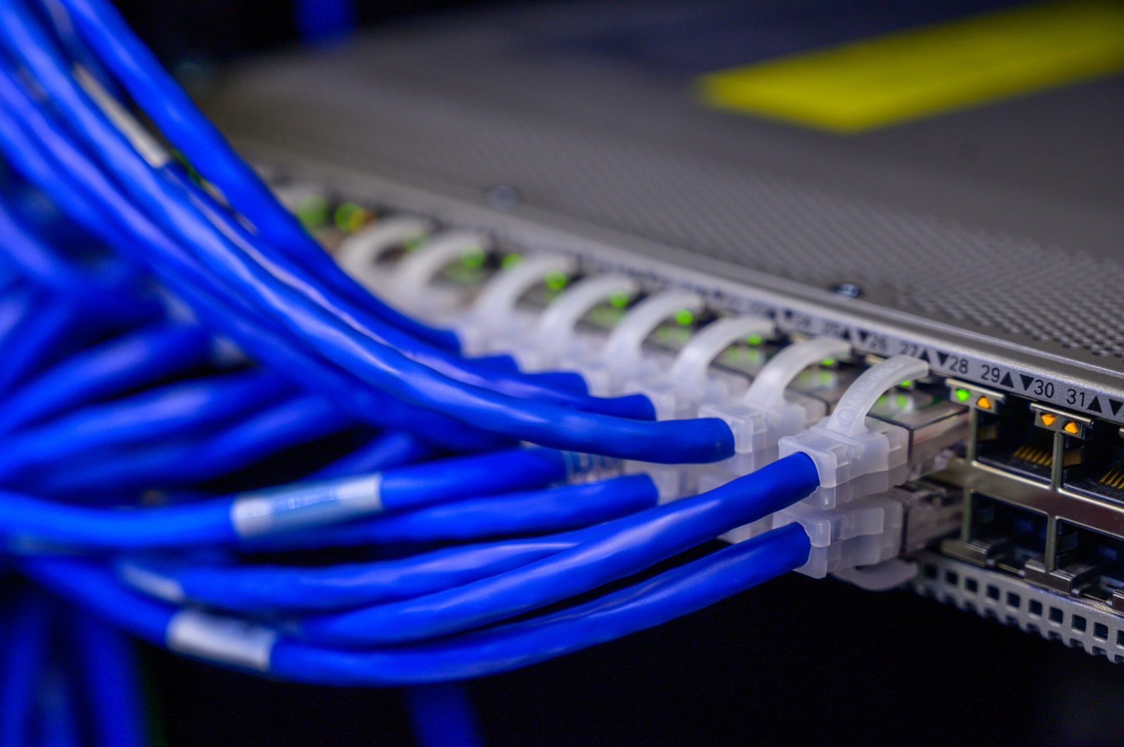 A professional telecommunications photography capturing glowing data transmission ports representing how the Verizon Fios 5Gbps fiber plan functions
