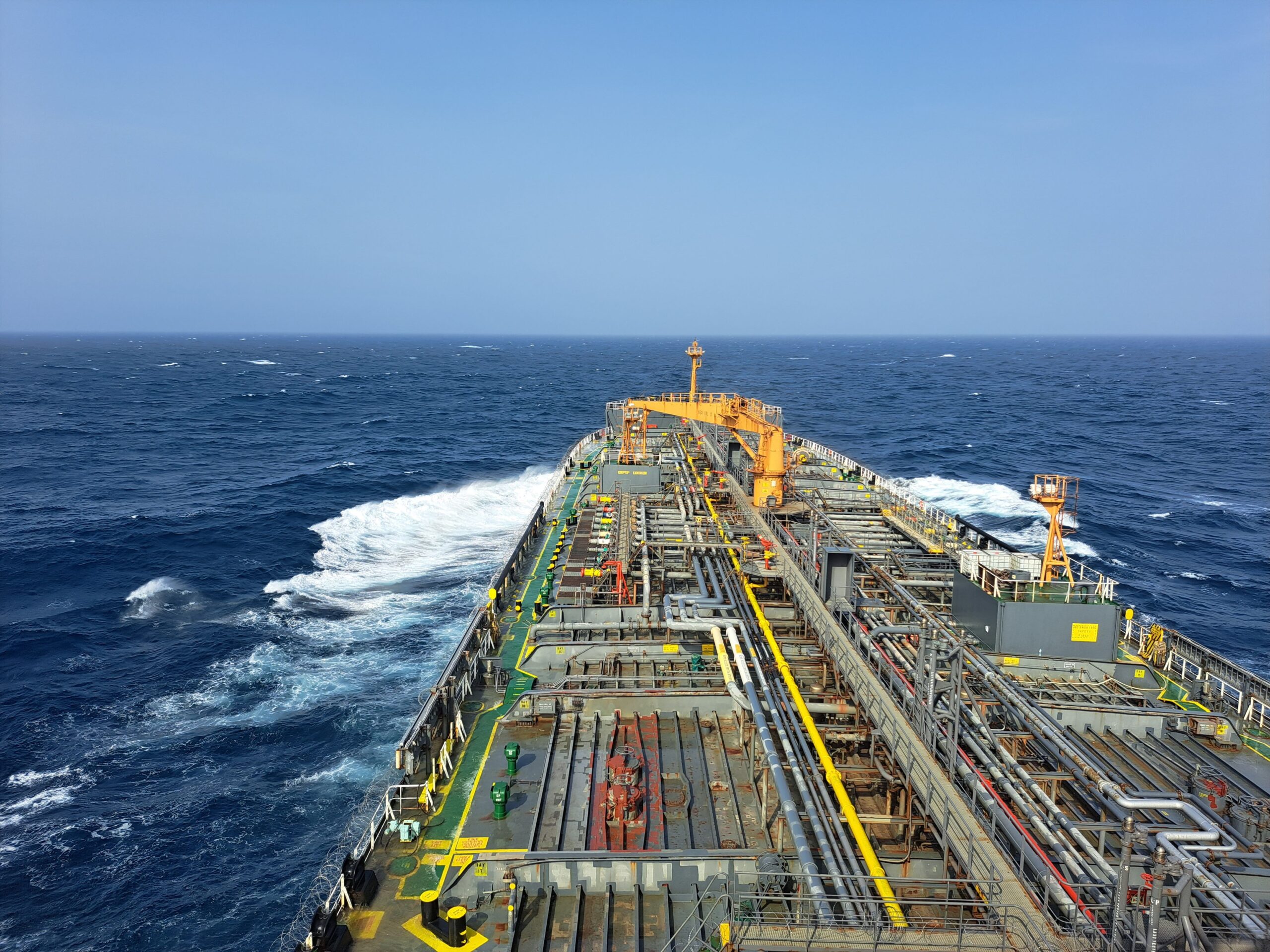 A massive commercial cargo cargo vessel navigating dark ocean waters during evening twilight