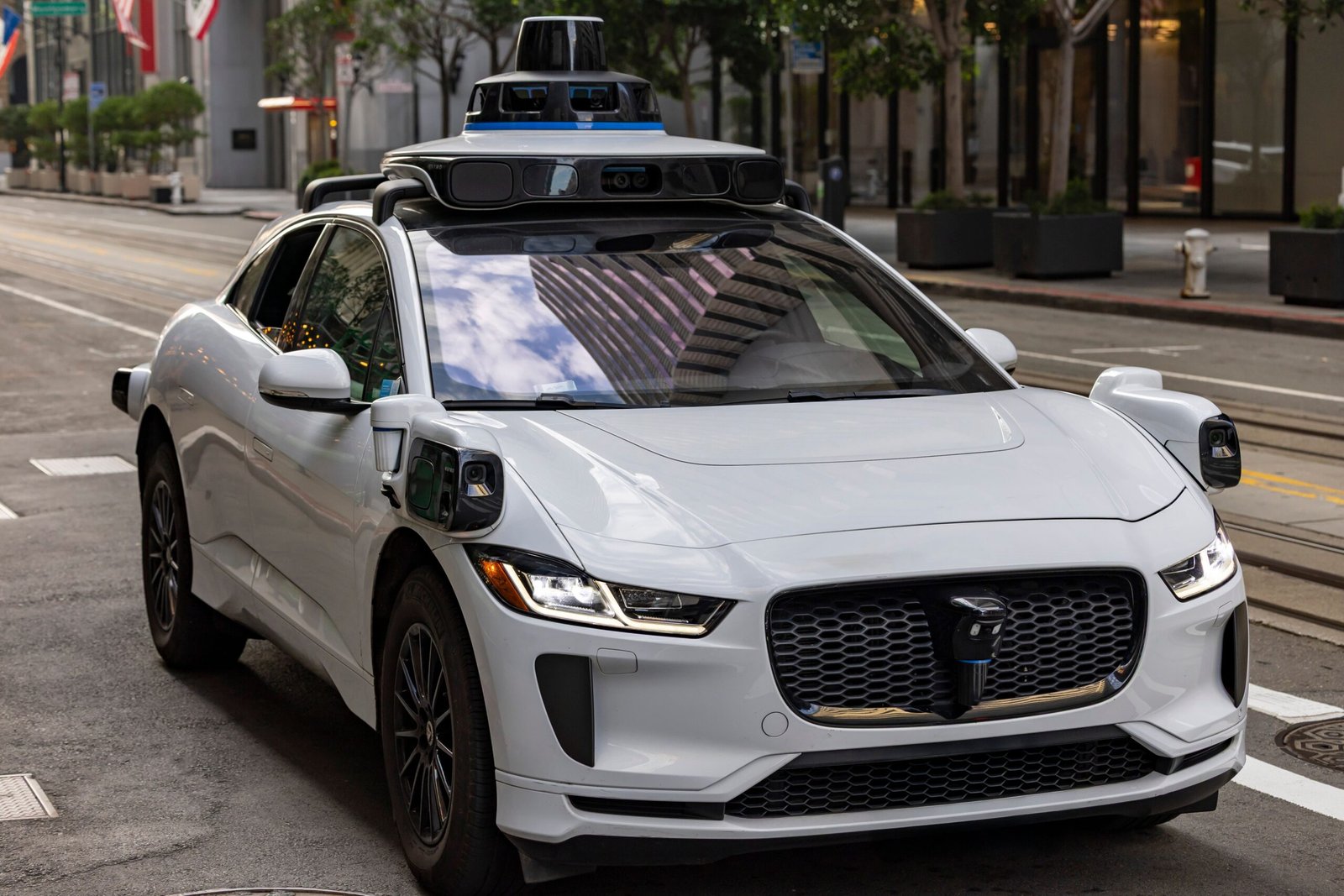 A professional autonomous logistics photograph capturing top-mounted vehicle lidar sensors representing the context of the Waymo San Francisco autonomous service pause