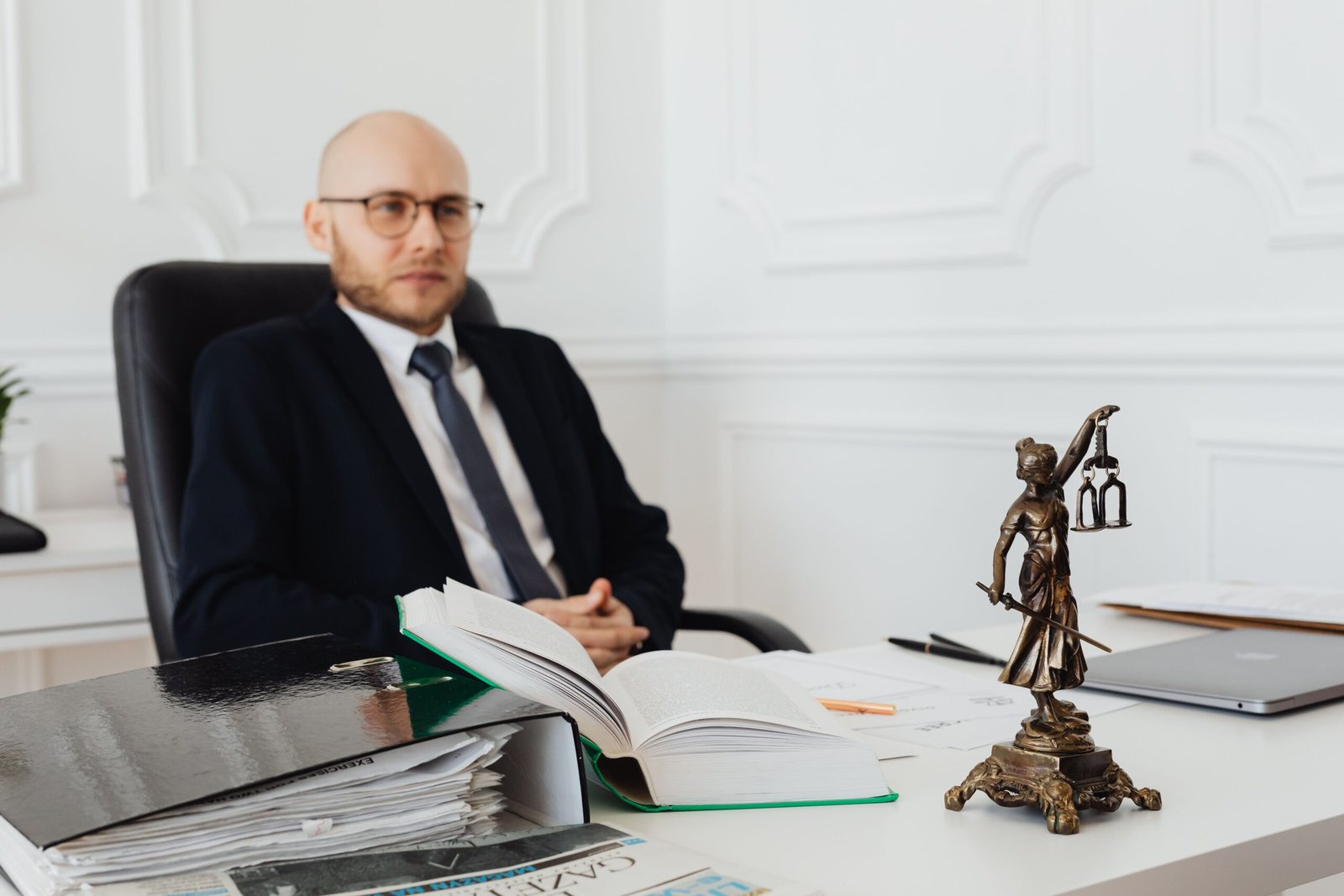 Legal scales of justice alongside car insurance policy documents and law firm consultation notebook